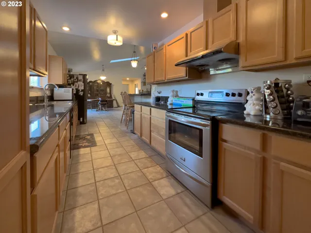 a kitchen with stainless steel appliances granite countertop a stove a sink and a refrigerator