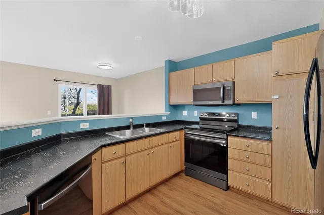 a kitchen with granite countertop a refrigerator stove and microwave