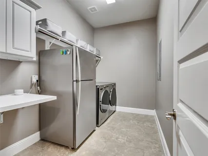 a utility room with cabinets washer and dryer