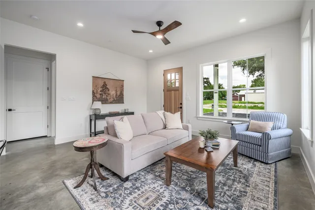 a living room with furniture a rug and a large window