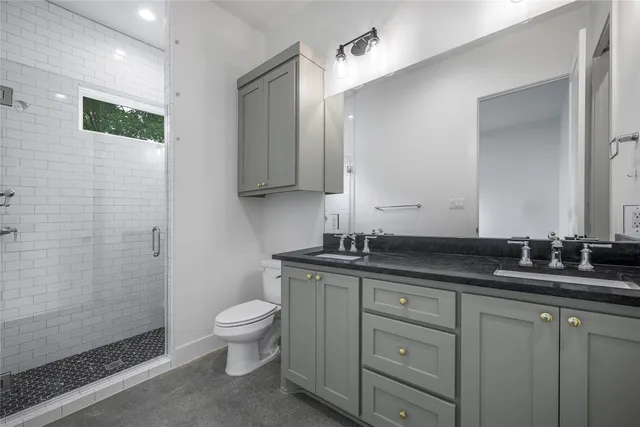 a bathroom with a granite countertop sink a toilet and a mirror