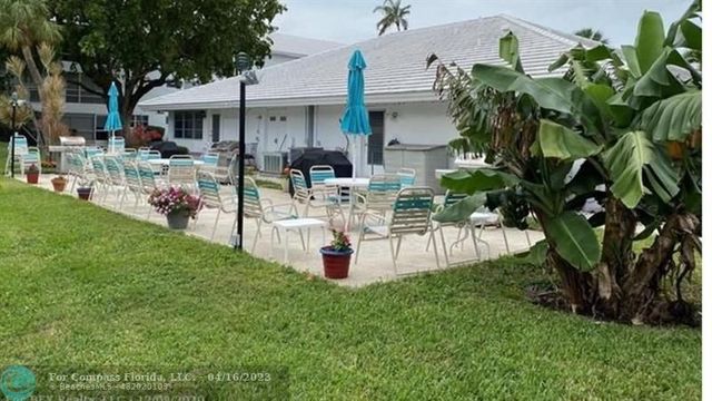 a view of a house with a yard and sitting area