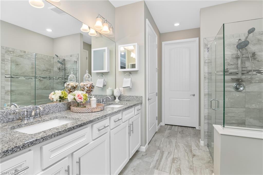 19826 Bittersweet Lane Estero, FL 33928 - Photo 19 of 50 a bathroom with a granite countertop sink mirror and shower