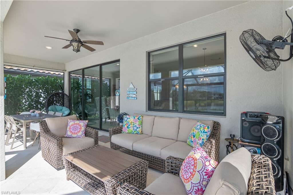 19826 Bittersweet Lane Estero, FL 33928 - Photo 26 of 50 a living room with furniture and a floor to ceiling window