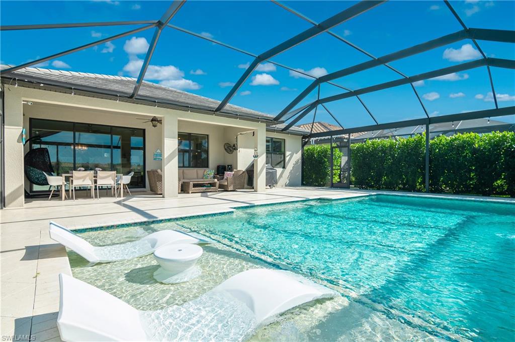 19826 Bittersweet Lane Estero, FL 33928 - Photo 31 of 50 a view of a backyard with table and chairs under an umbrella