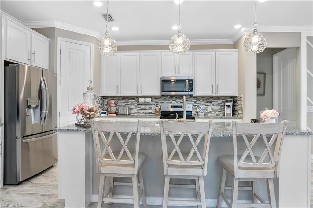 19826 Bittersweet Lane Estero, FL 33928 - Photo 8 of 50 a kitchen with stainless steel appliances a refrigerator sink and cabinets
