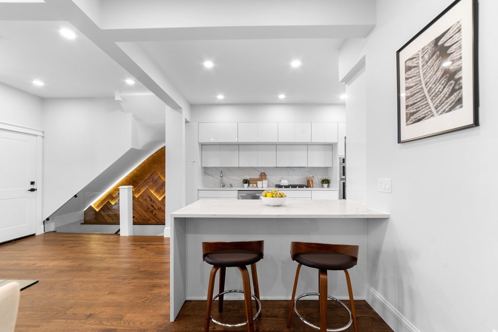 615 East 3rd Street, Unit 1 Boston, MA 02127 - Photo 18 of 42 a kitchen with stainless steel appliances wooden cabinets and wooden floor