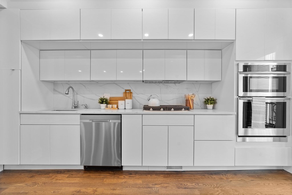 615 East 3rd Street, Unit 1 Boston, MA 02127 - Photo 20 of 42 a kitchen with stainless steel appliances granite countertop a sink and cabinets with wooden floor
