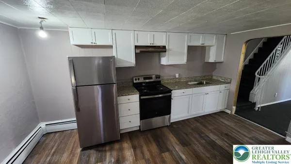 a kitchen with a sink a refrigerator and cabinets