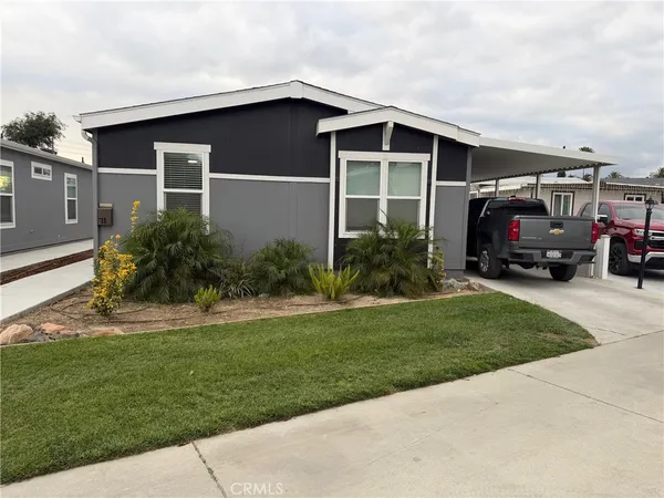 a view of house and yard with car parked