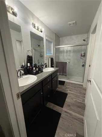 a bathroom with a double vanity sink a toilet a mirror and shower
