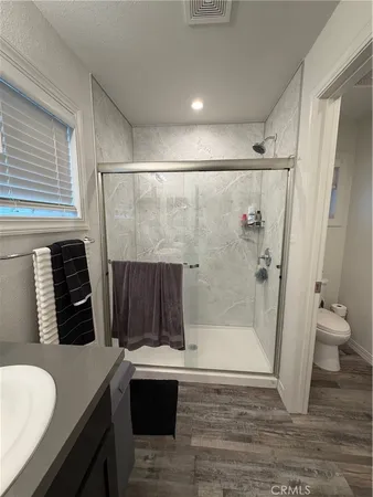 a bathroom with a sink a toilet and shower
