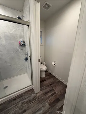 a bathroom with a granite countertop shower and a toilet