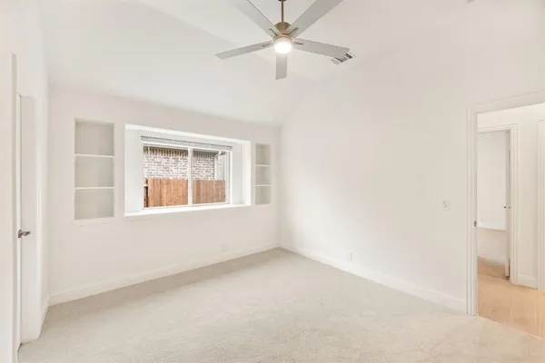 an empty room with a window and a fan