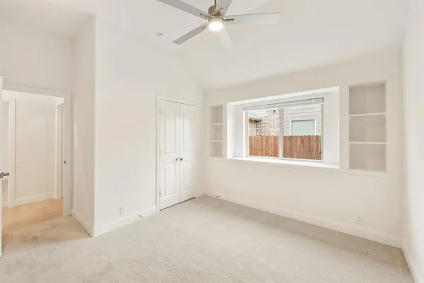 an empty room with a window and a ceiling fan