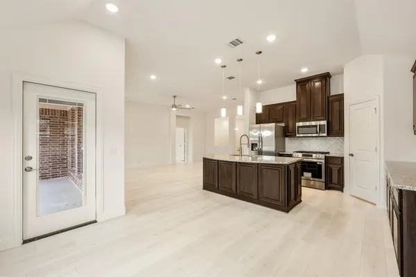 a large kitchen with stainless steel appliances kitchen island granite countertop a large counter top cabinets and stainless steel appliances