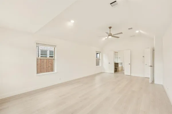 an empty room with ceiling fan and window