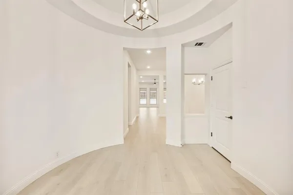 a view of a hallway with a chandelier fan