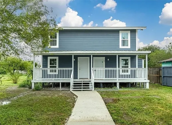 a view of a house with a yard and sitting area