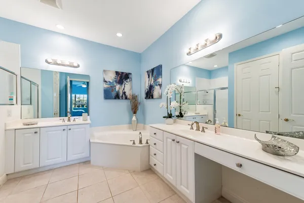 a large bathroom with a double vanity sink mirror and bathtub