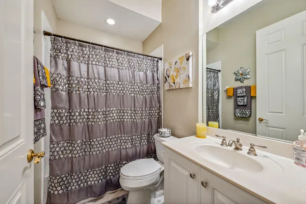 a bathroom with a sink toilet vanity and shower