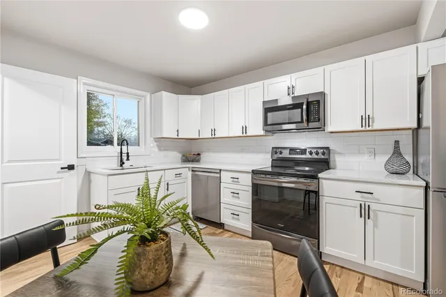 a kitchen with stainless steel appliances a stove a sink cabinets and a microwave