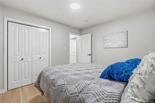 a bedroom with a bed and a painting on the wall