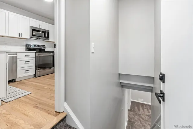 a kitchen with white cabinets and stainless steel appliances
