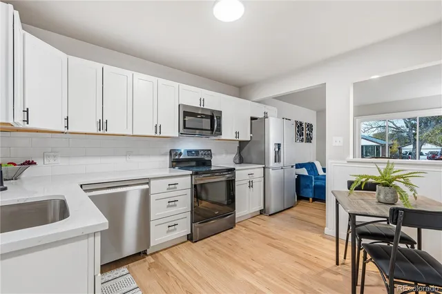 a kitchen with a sink white cabinets and white appliances