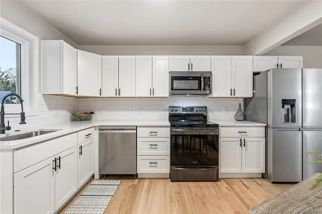a kitchen with a refrigerator stove and sink