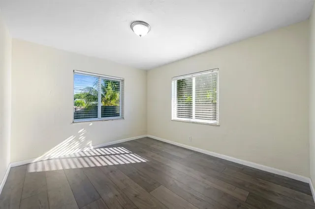 a view of an empty room with wooden floor