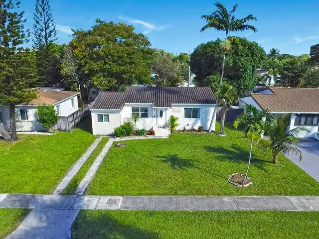 a front view of a house with a yard and trees