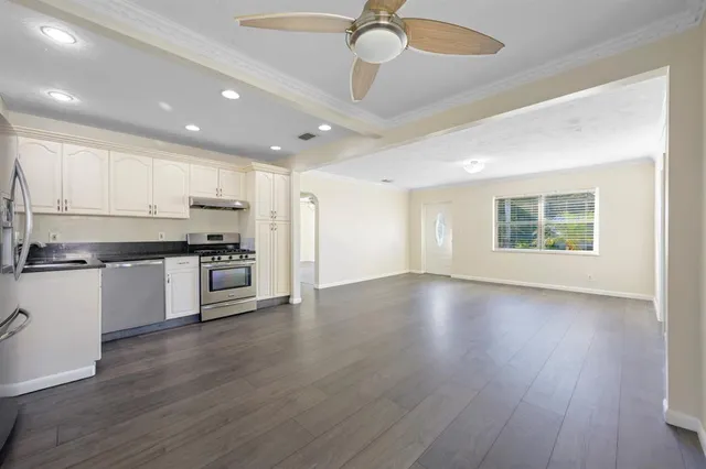 a view of kitchen with granite countertop stainless steel appliances and cabinets