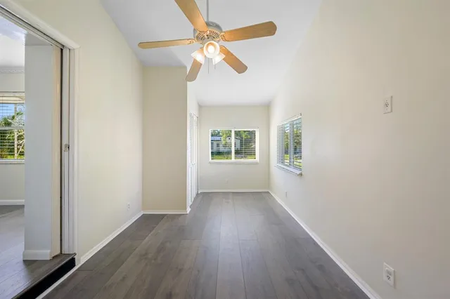 a view of an empty room with a window and wooden floor