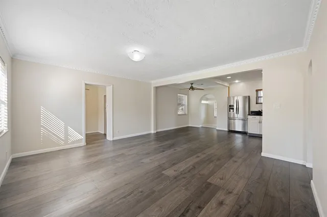 a view of empty room with a fireplace and wooden floor