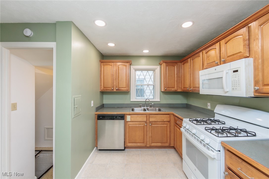 1232 Avondale Road Cleveland, OH 44121 - Photo 13 of 46 Kitchen with recessed lighting, white appliances, light tile patterned flooring, and a sink