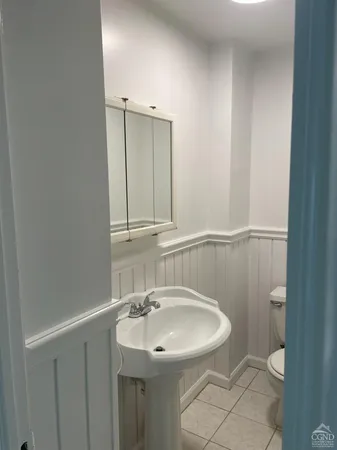 a bathroom with a sink a toilet and mirror