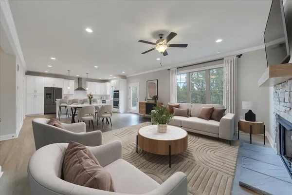 a living room with furniture kitchen view and a large window