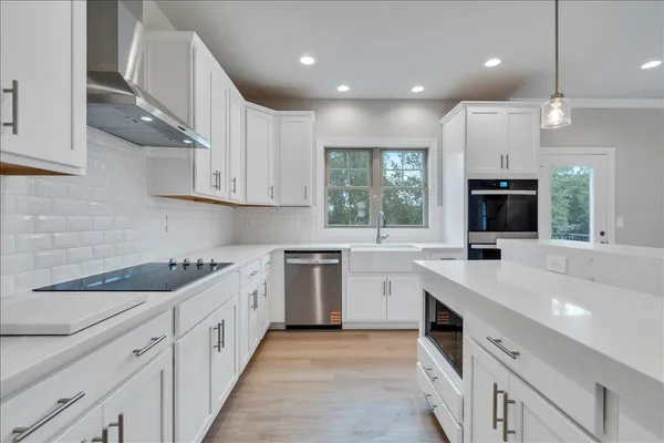 a kitchen with granite countertop a sink stainless steel appliances and cabinets