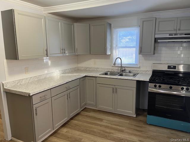 84 Point Road Flanders, NY 11901 - Photo 2 of 12 Kitchen with gray cabinetry, gas range, light countertops, decorative backsplash, and crown molding