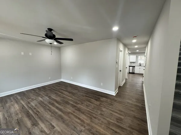 a view of a room with wooden floor and a ceiling fan