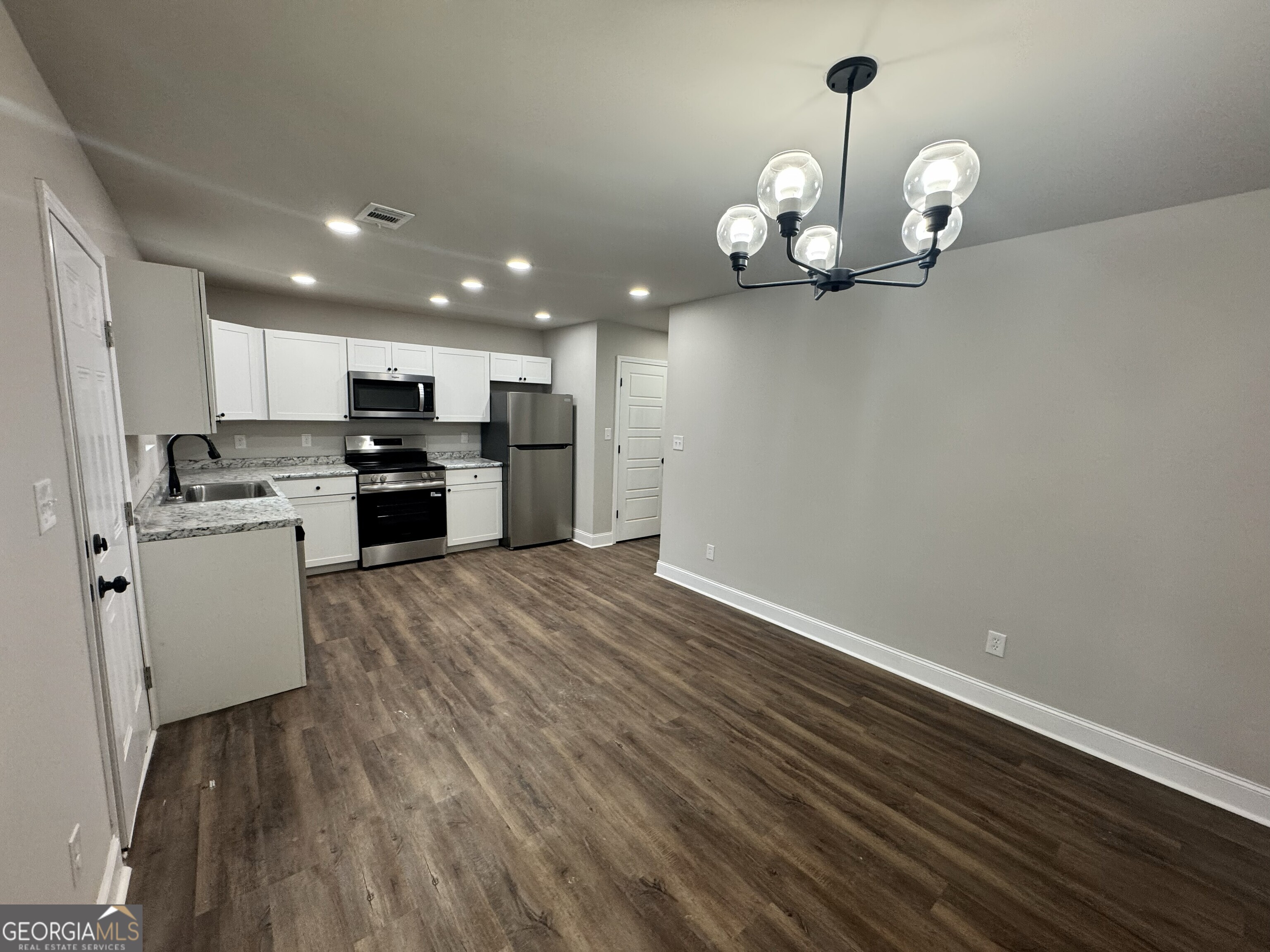 305 North 4th Street Warner Robins, GA 31093 - Photo 7 of 17 a view of a kitchen with wooden floor and stainless steel appliances