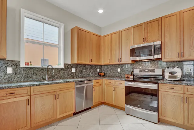 a kitchen with stainless steel appliances granite countertop a stove a sink and a microwave