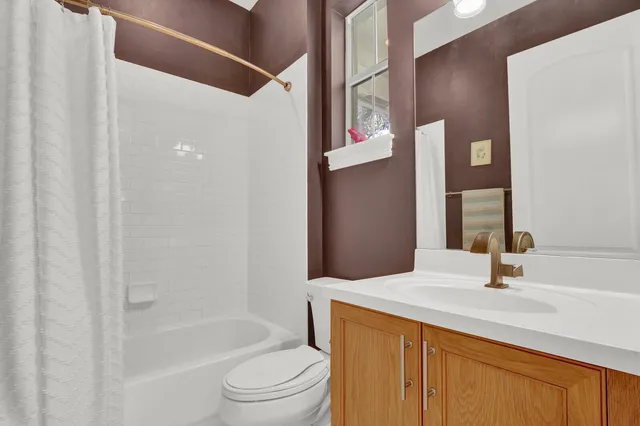 a bathroom with a bathtub shower sink vanity and toilet