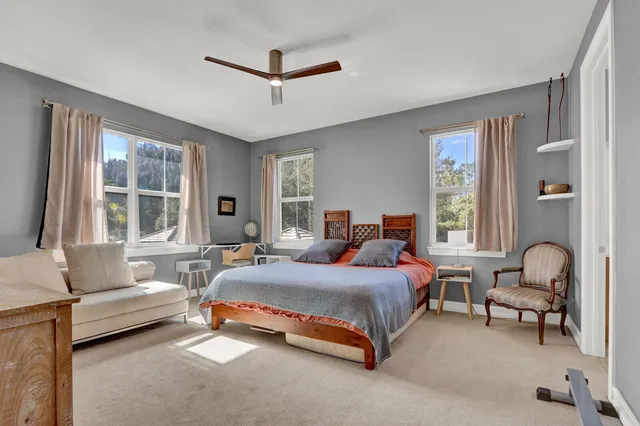 a bedroom with a bed a couch and windows