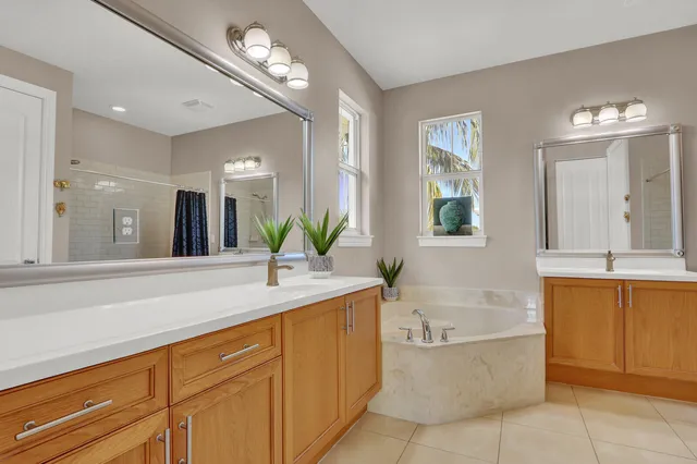 a bathroom with a bathtub a double vanity sink and a mirror