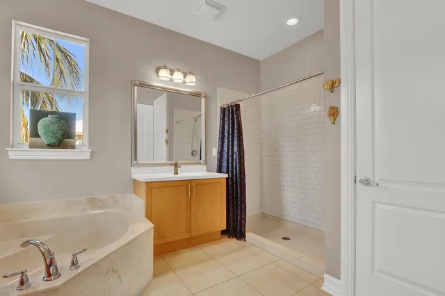 a bathroom with a tub a sink and a shower
