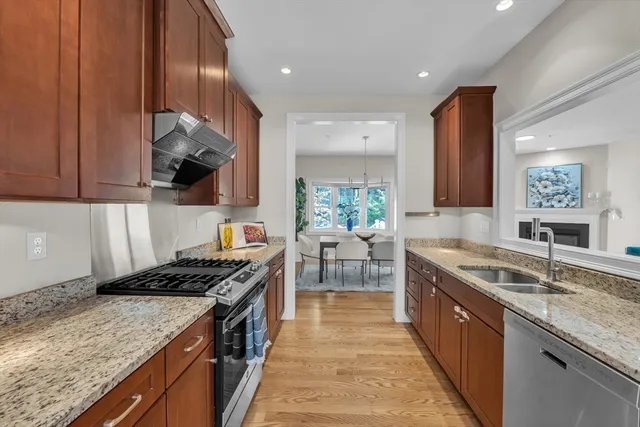 a kitchen with stainless steel appliances granite countertop a stove a sink and a microwave
