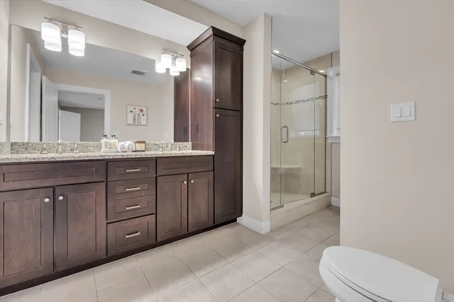 a bathroom with a granite countertop sink toilet mirror and bathtub