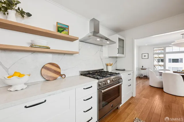 a kitchen with stainless steel appliances granite countertop a stove and a wooden floors